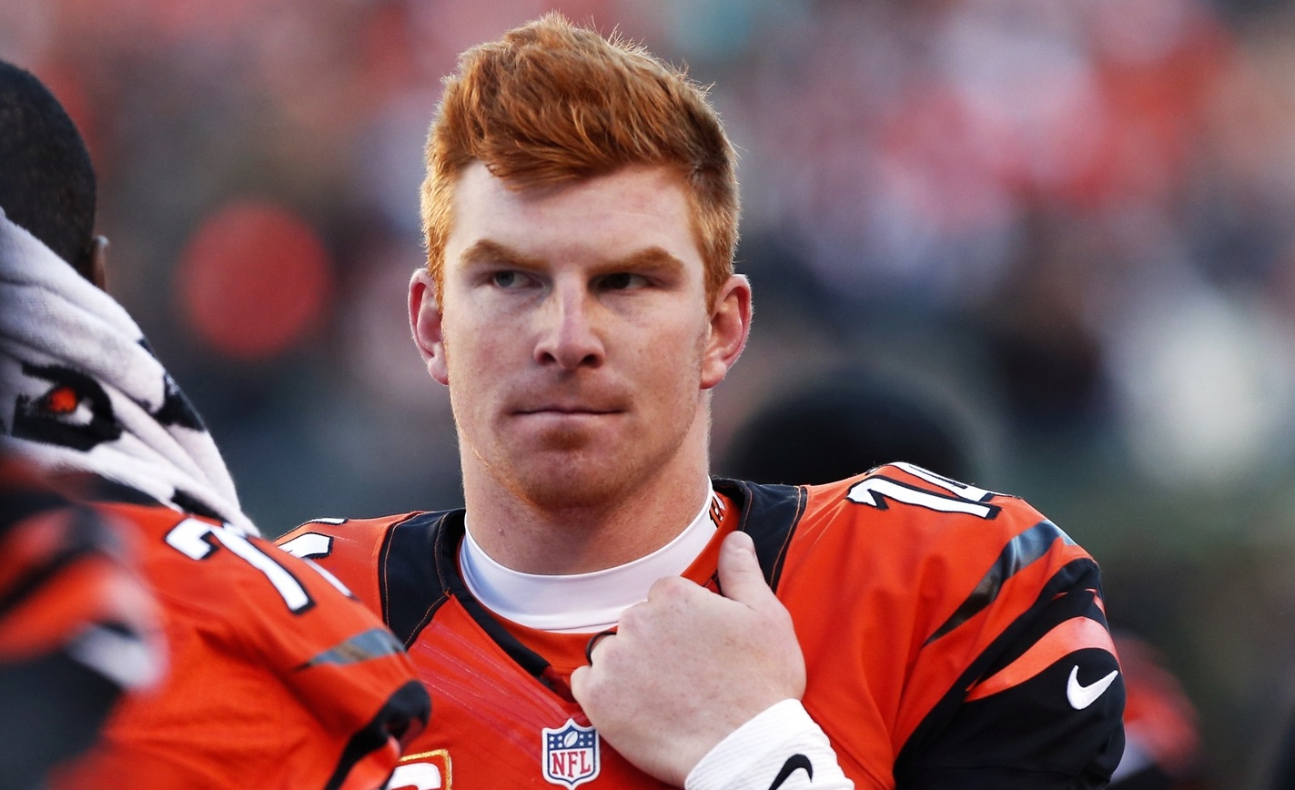 Andy Dalton grabs the collar of his jersey while standing on the sideline