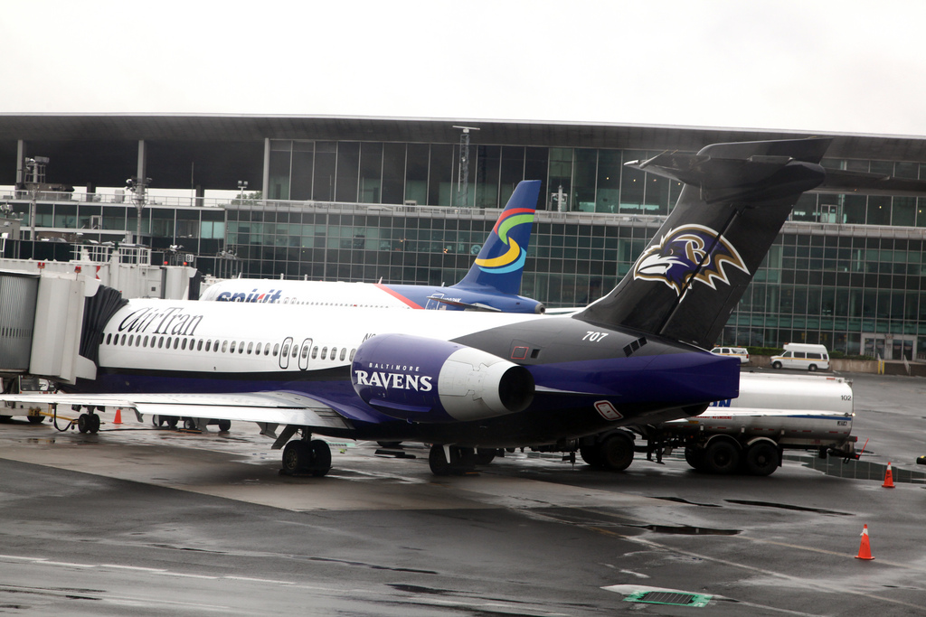 A Ravens plane with the team logo on the wing tips and fin.
