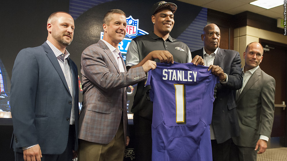 Members of the Baltimore Ravens front office post with first-round draft pick Ronnie Stanley, who holds up his jersey.