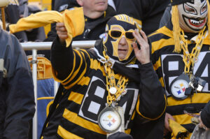Douchey Steelers fan waving around a Terrible Towel and wearing a Steelers chain clock.
