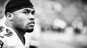 Baltimore Ravens WR Steve Smith stares in black and white with his helmet off and pads on.