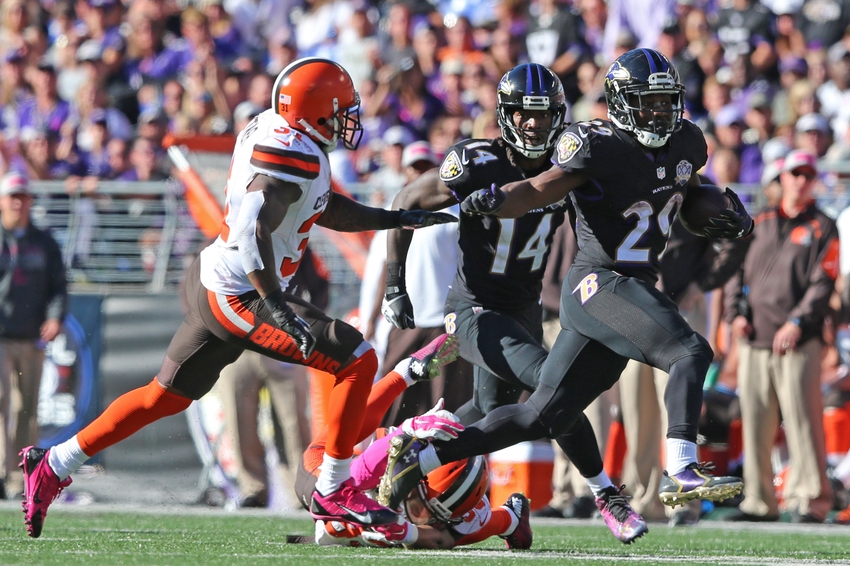 Justin Forsett of the Ravens runs past Cleveland Browns players.