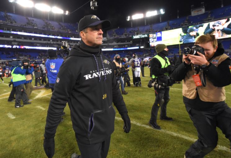 John Harbaugh walks through photographers after the team's crushing loss that ended their season.