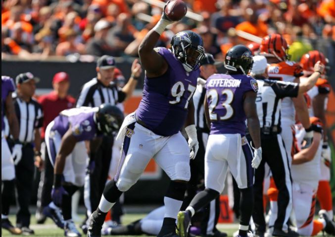 The Ravens' Michael Pierce holds up the ball after recovering a fumble against the Cincinnai Bengals.