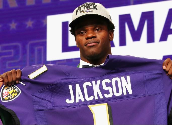 Lamar Jackson holds up his Ravens jersey.