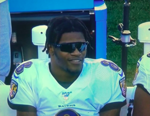 Lamar Jackson in sunglasses on the bench.