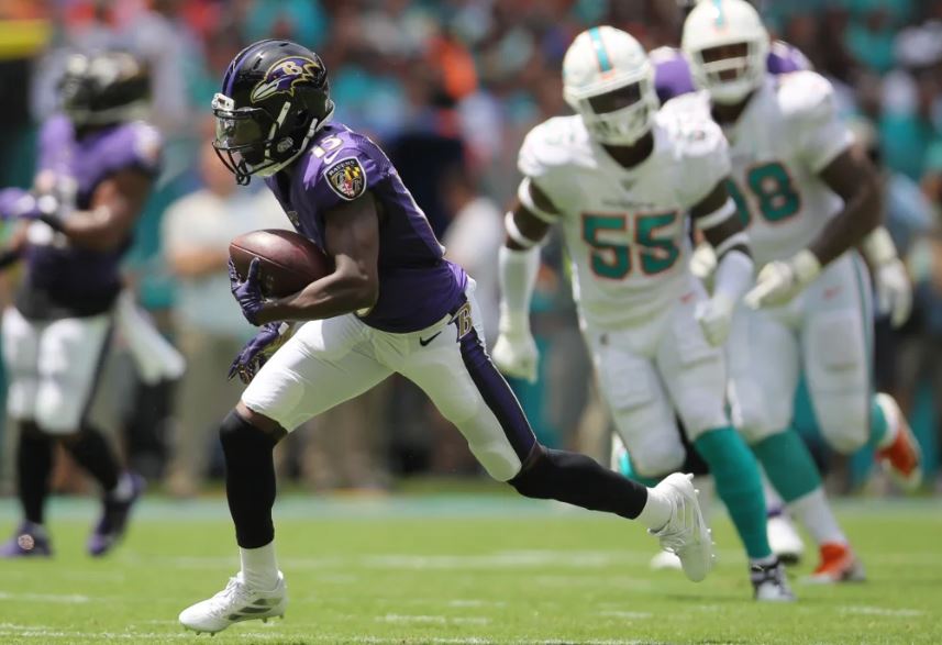 Marquise Brown runs from Defenders on the Dolphins.