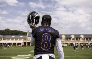 Lamar Jackson walks onto the field at camp